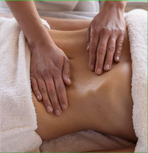 Person receiving a lymphatic massage on the abdomen area with a blurred background - Side View